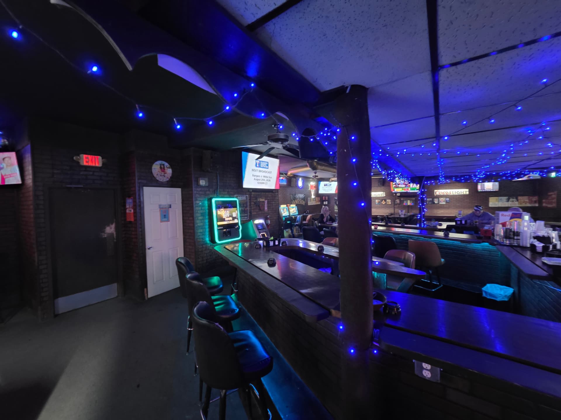 Corner of the bar with jukebox, gaming machines and string lights
