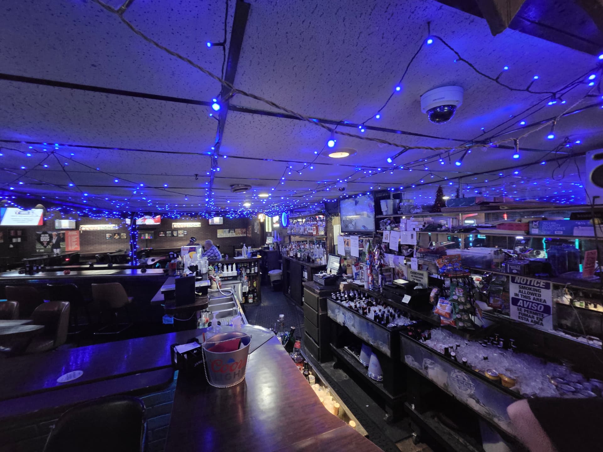 Back bar packed with bottles under the blue light canopy