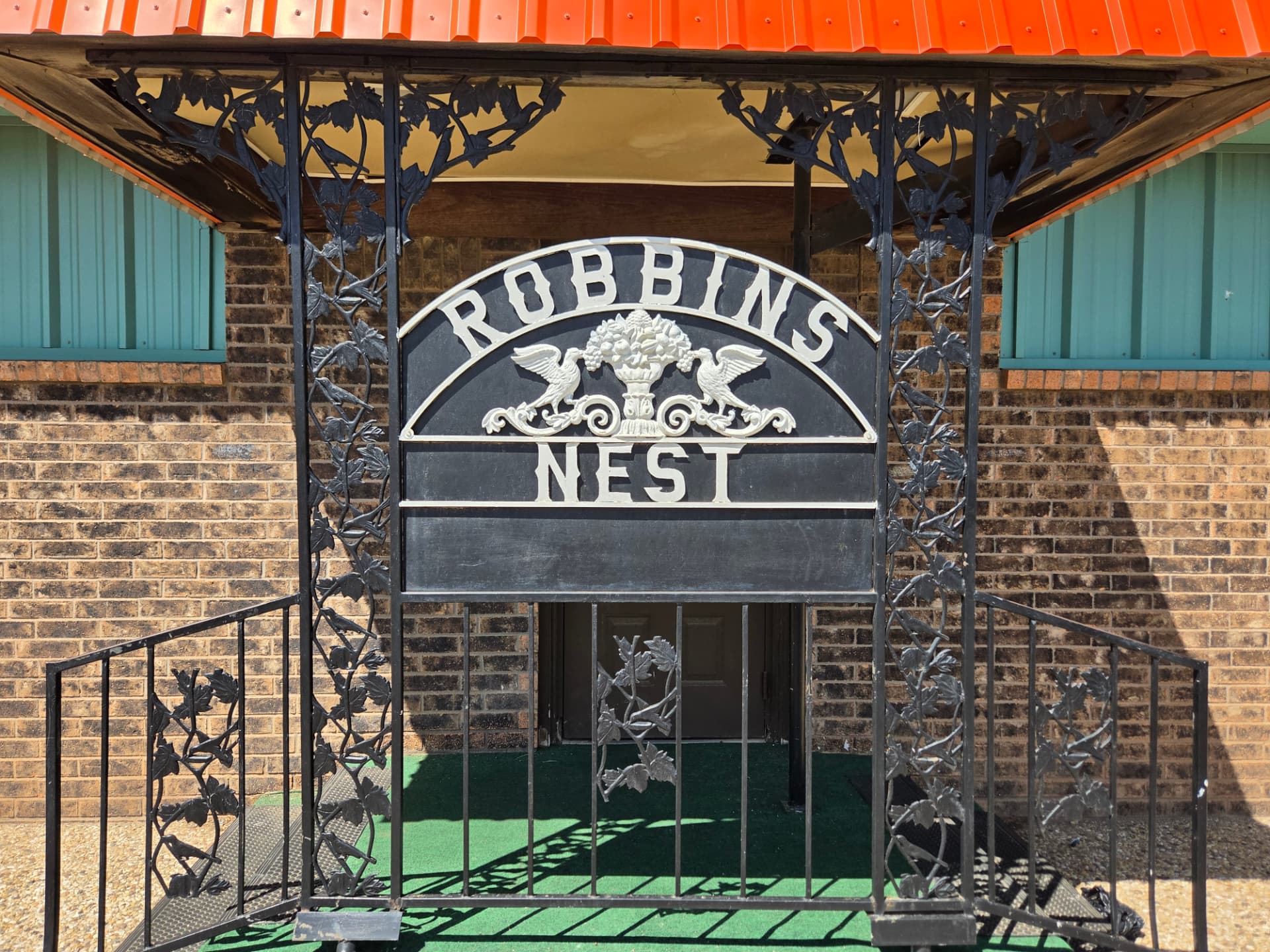 The cast-iron Robbins Nest sign over the front entrance gate
