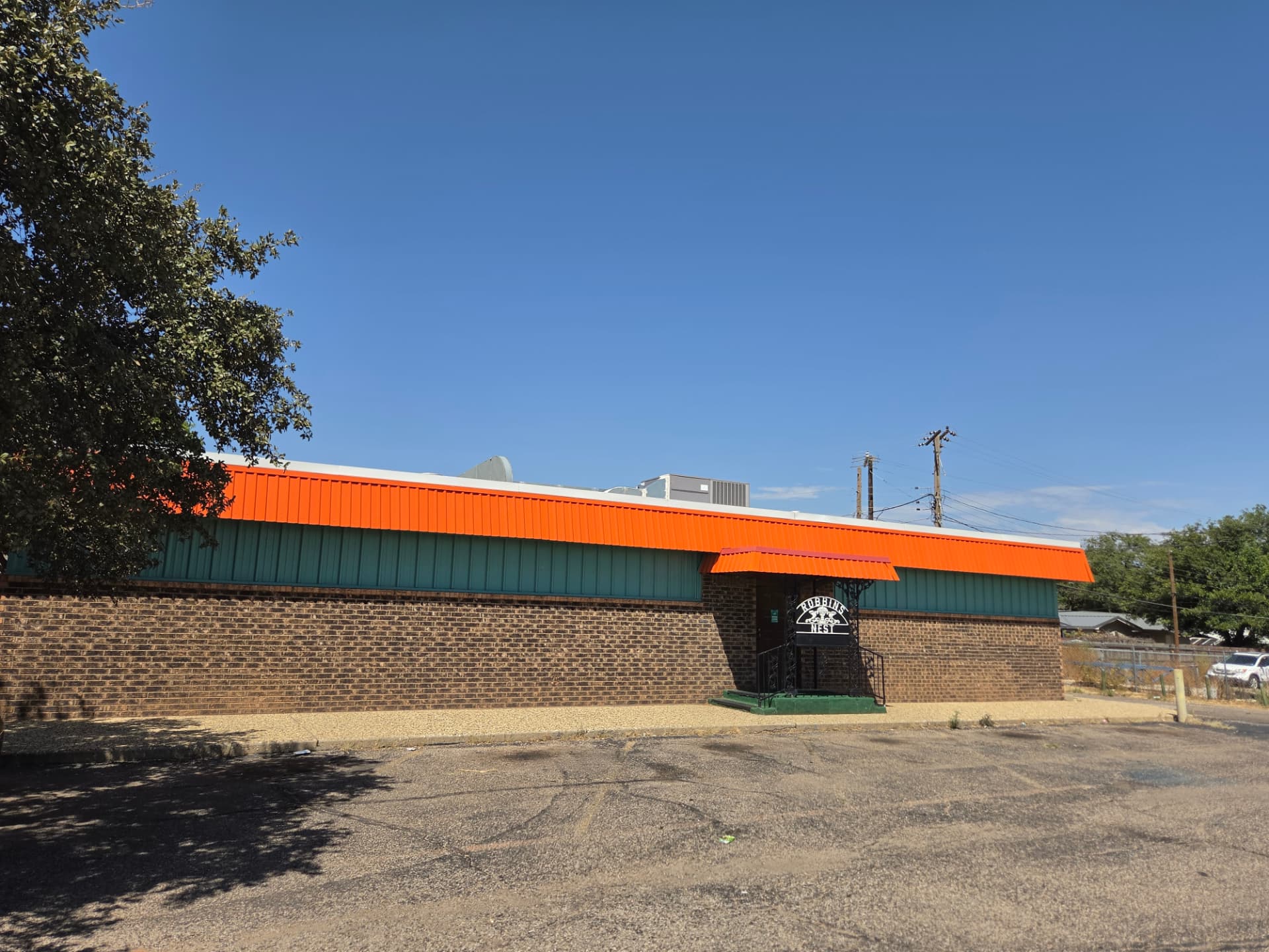 The orange and teal Robbins Nest building from the parking lot
